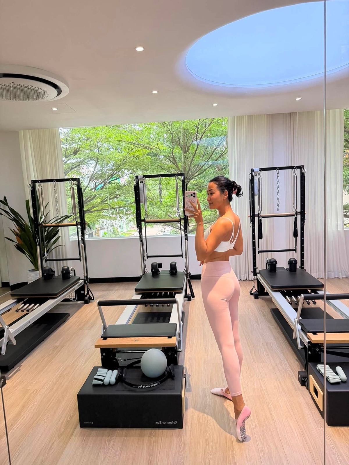 Pisey in her Phnom Penh reformer studio, morning light through the trees
